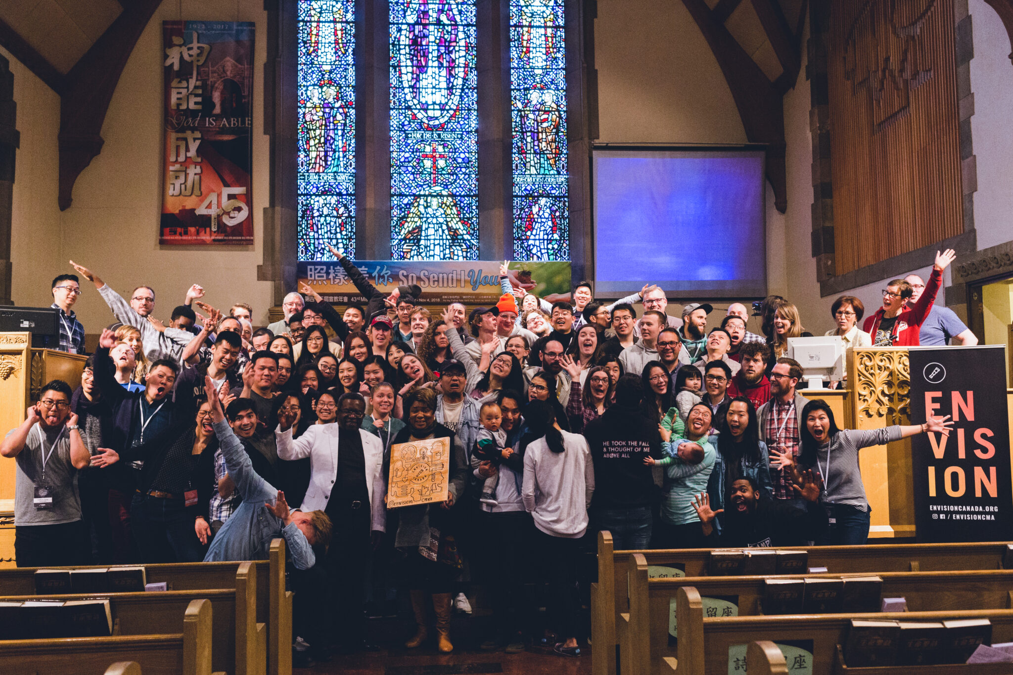 A group photo of the participants from Envision Summit 2019 are standing at the front of a church smiling at the camera.