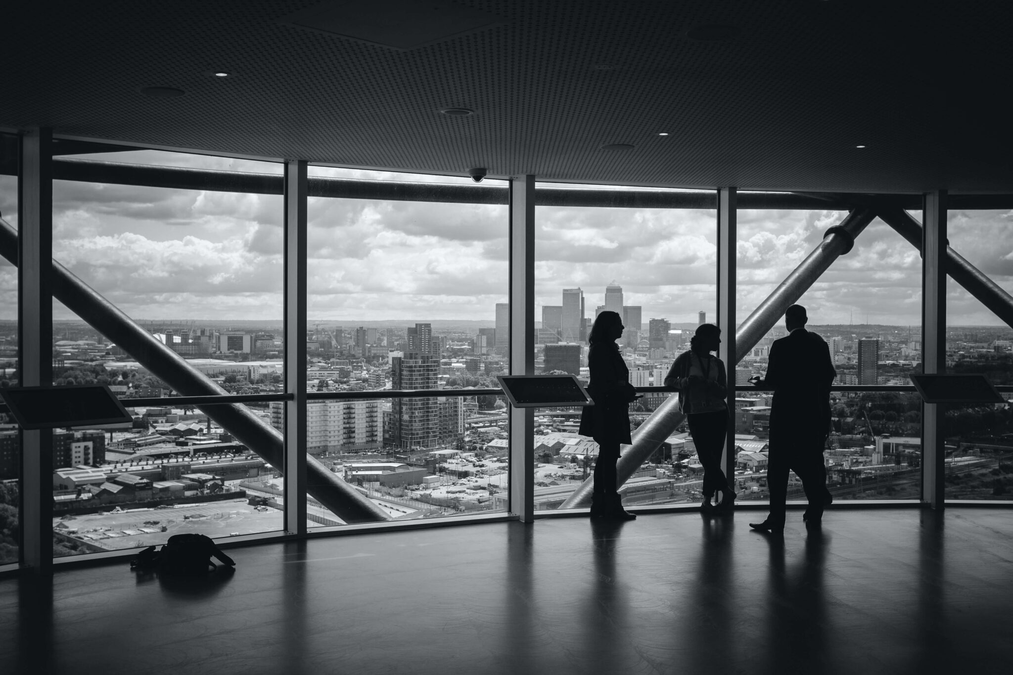 Three people in an office building overlooking a city skyline