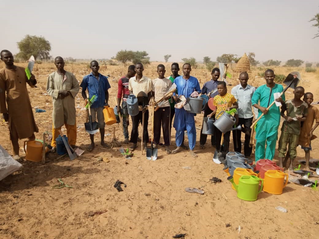 A group photo of people in Niger with their new gardening tools