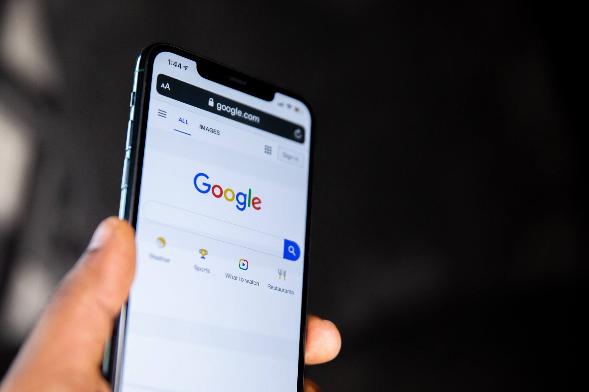 A person holding a mobile phone with a google search on the screen