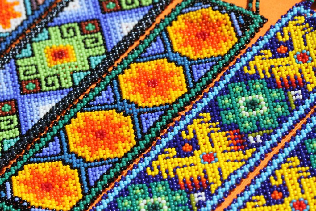 A close up shot of a colourful Huichol bead pattern