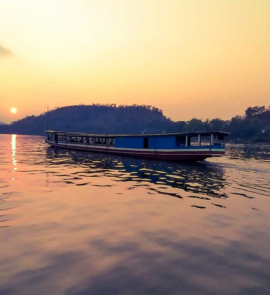 Laotian boat on the water at sunset.