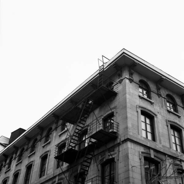 black and white photo of the top of a stone apartment building