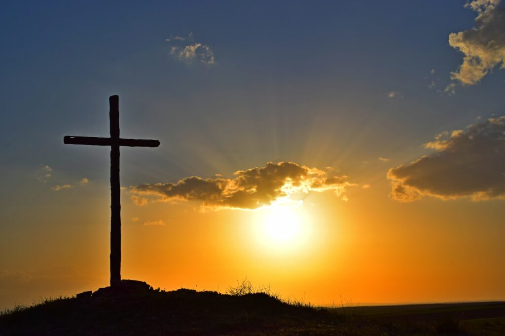cross with setting sun behind it