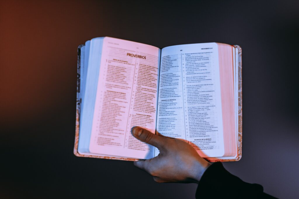 Spanish Bible open to the book of Proverbs with a dark background